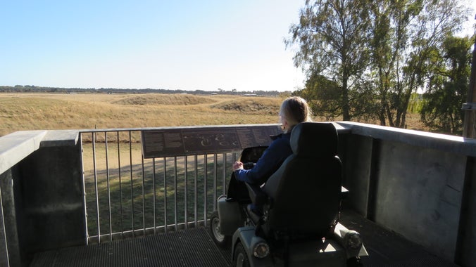 A visitor sitting in a powered electric vehicle on the first level of the viewing tower at Sutton Hoo